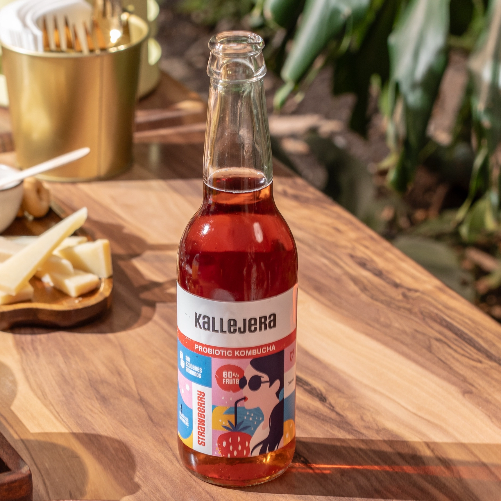 Botella de kombucha Kallejera sabor fresa en mesa de madera.